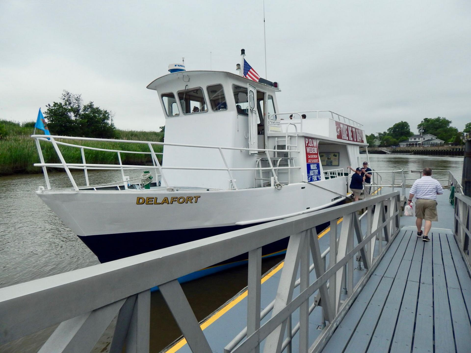 The Delafort passenger boat beside a boarding walkway, with visitors at the dock