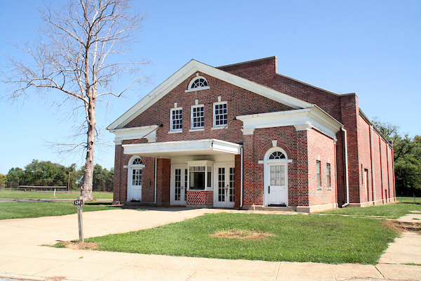 Red-brick Fort DuPont theater with a columned entrance and lawn