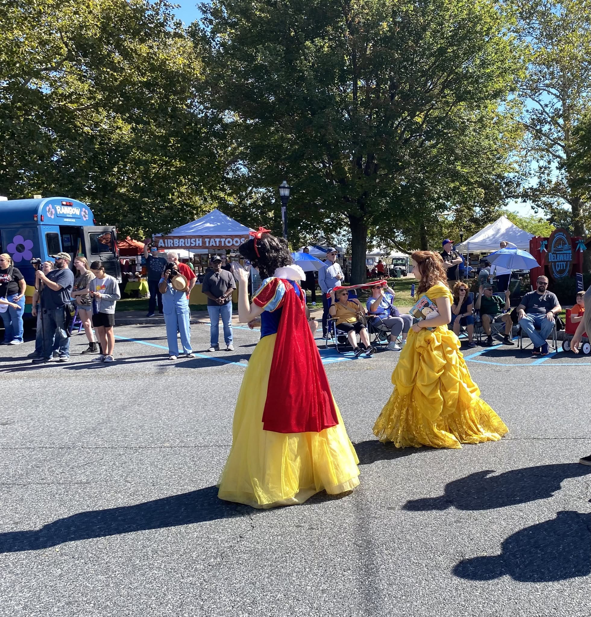 Performers dressed as Snow White and Belle greeting attendees
