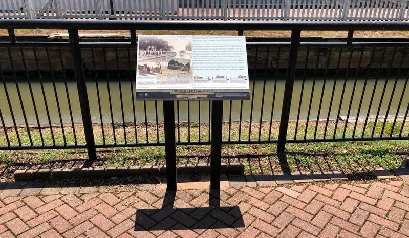 The interpretive sign and preserved Delaware City canal lock behind its railing