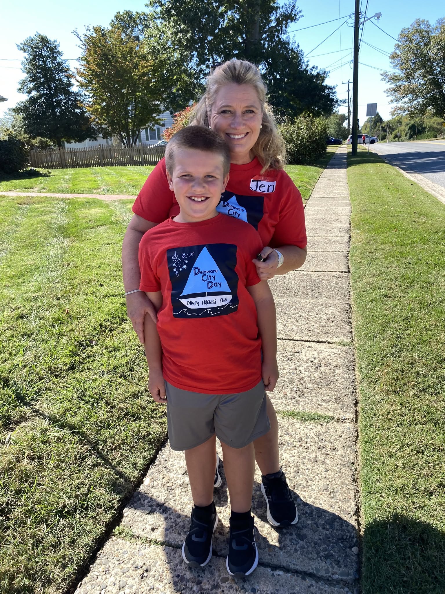 A woman and boy wearing matching red Delaware City Day T-shirts