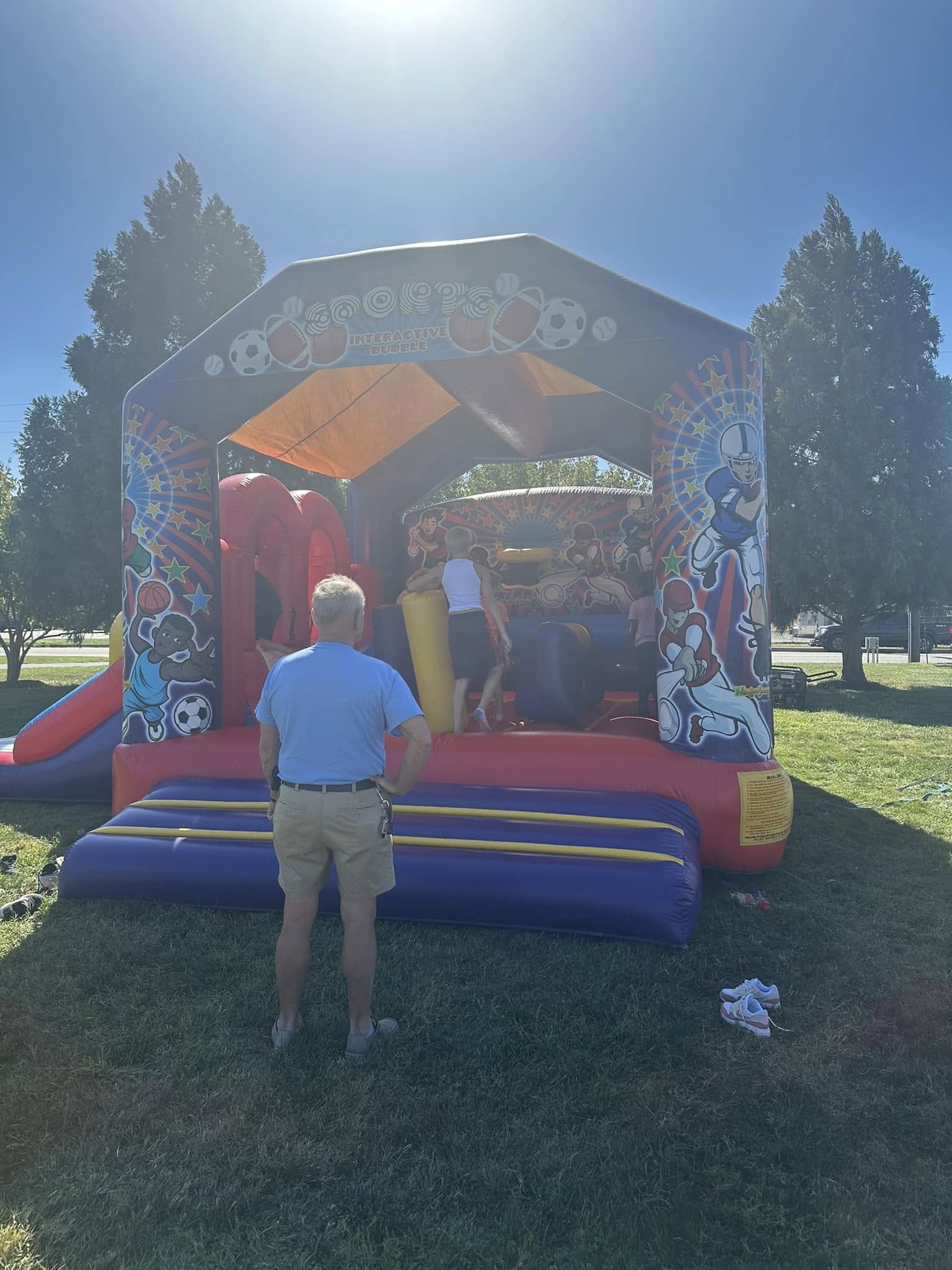A festival worker standing behind an inflatable bounce house