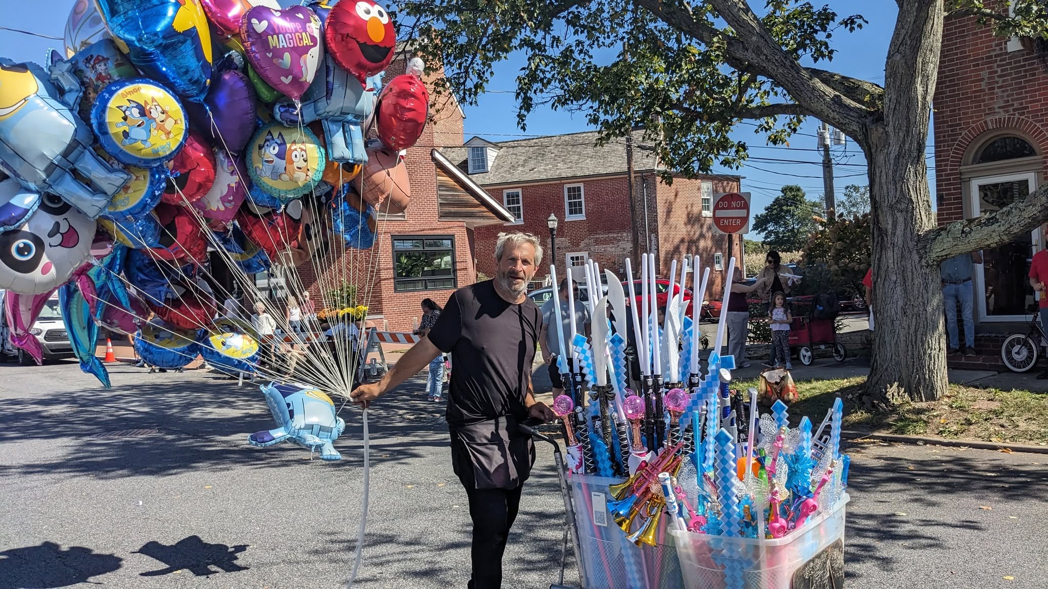 A vendor carrying a bundle of character balloons