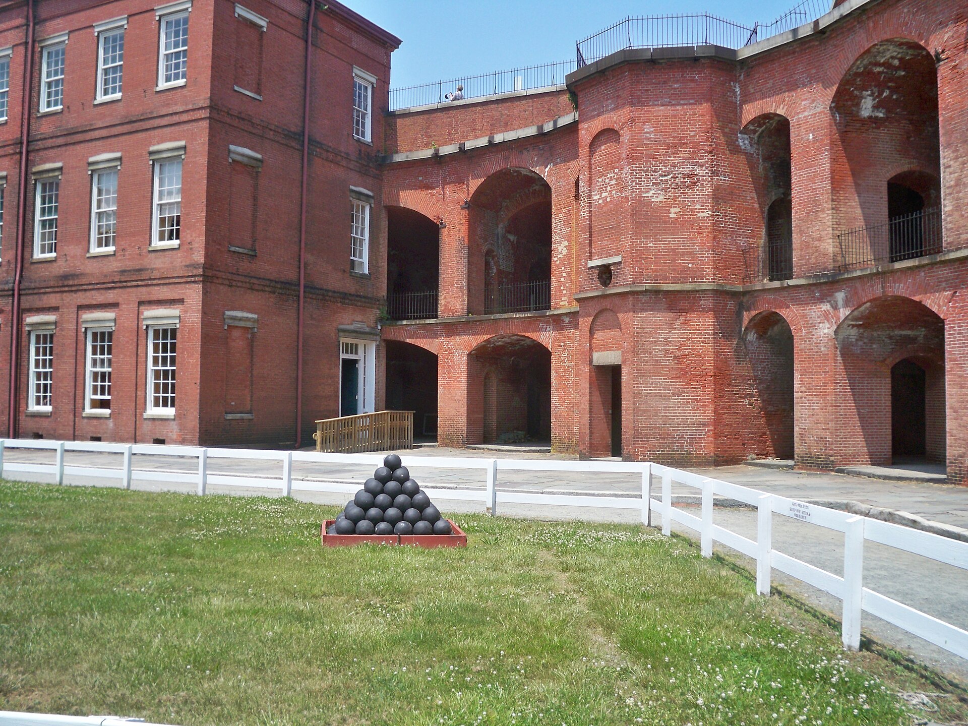 A stack of cannonballs in the grassy courtyard of Fort Delaware
