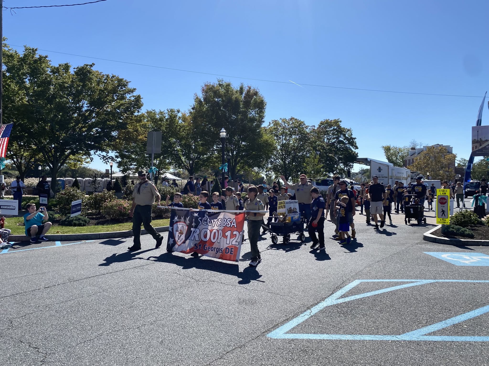 A marching group carrying a banner along the parade route
