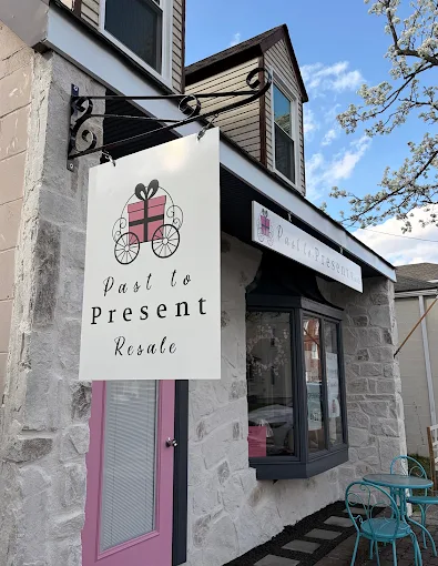 Past to Present Resale storefront with a pink door, shop window and hanging sign