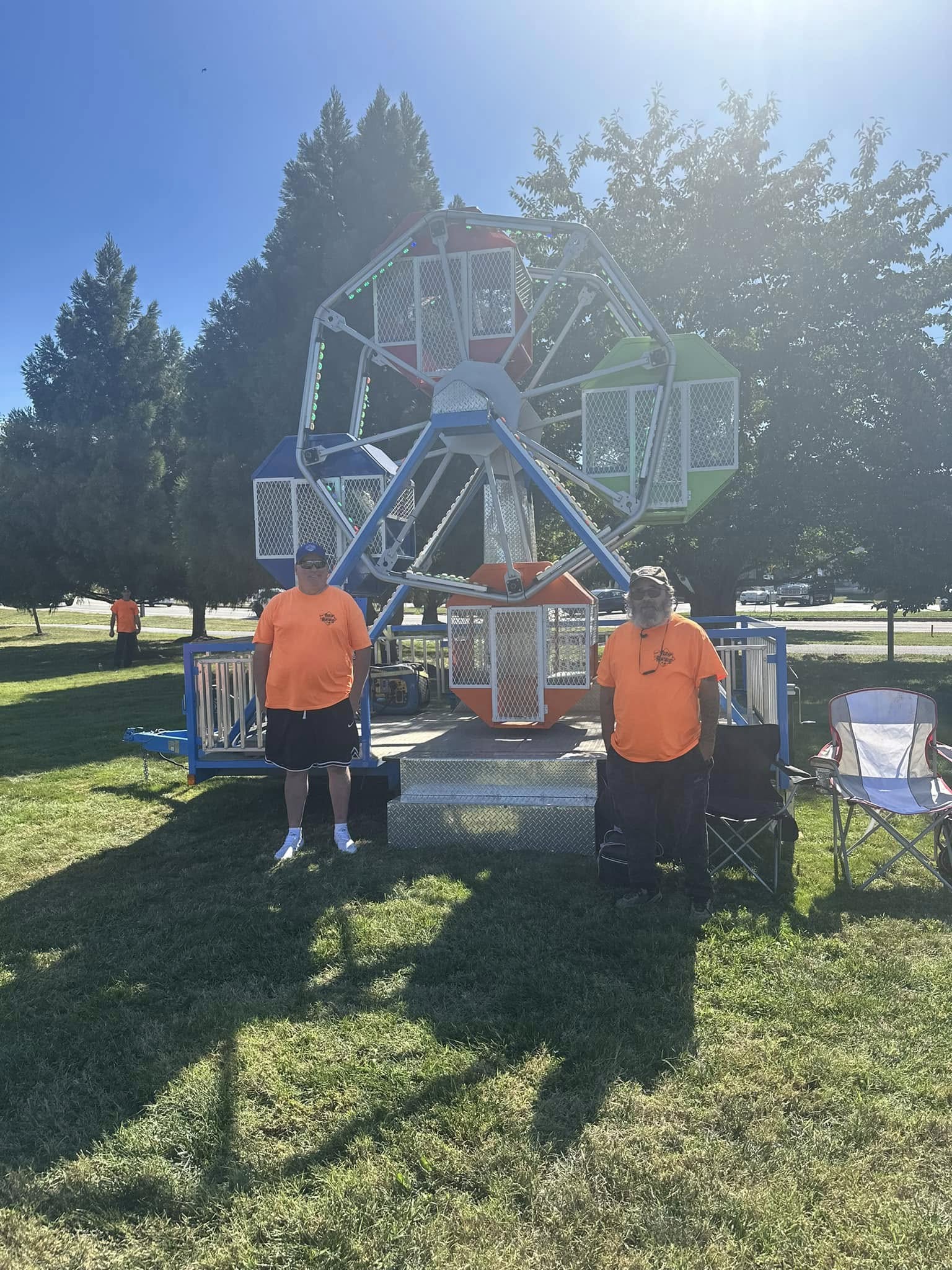 A small Ferris wheel turning against a blue sky
