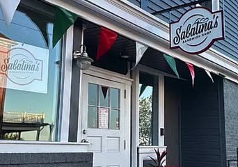 Sabatina’s Sandwich Shop entrance with a hanging sign and American flag