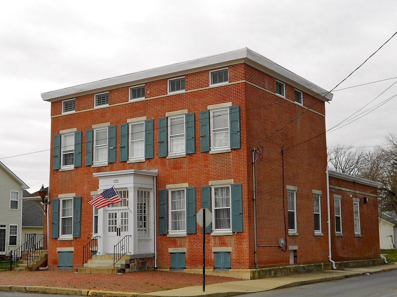Former Delaware City National Bank, a red-brick building with pale shutters and a central entrance at 122 Washington Street