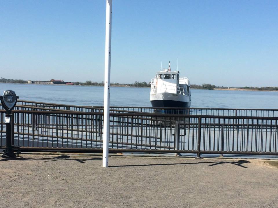 A white passenger ferry beyond the waterfront railing in Delaware City