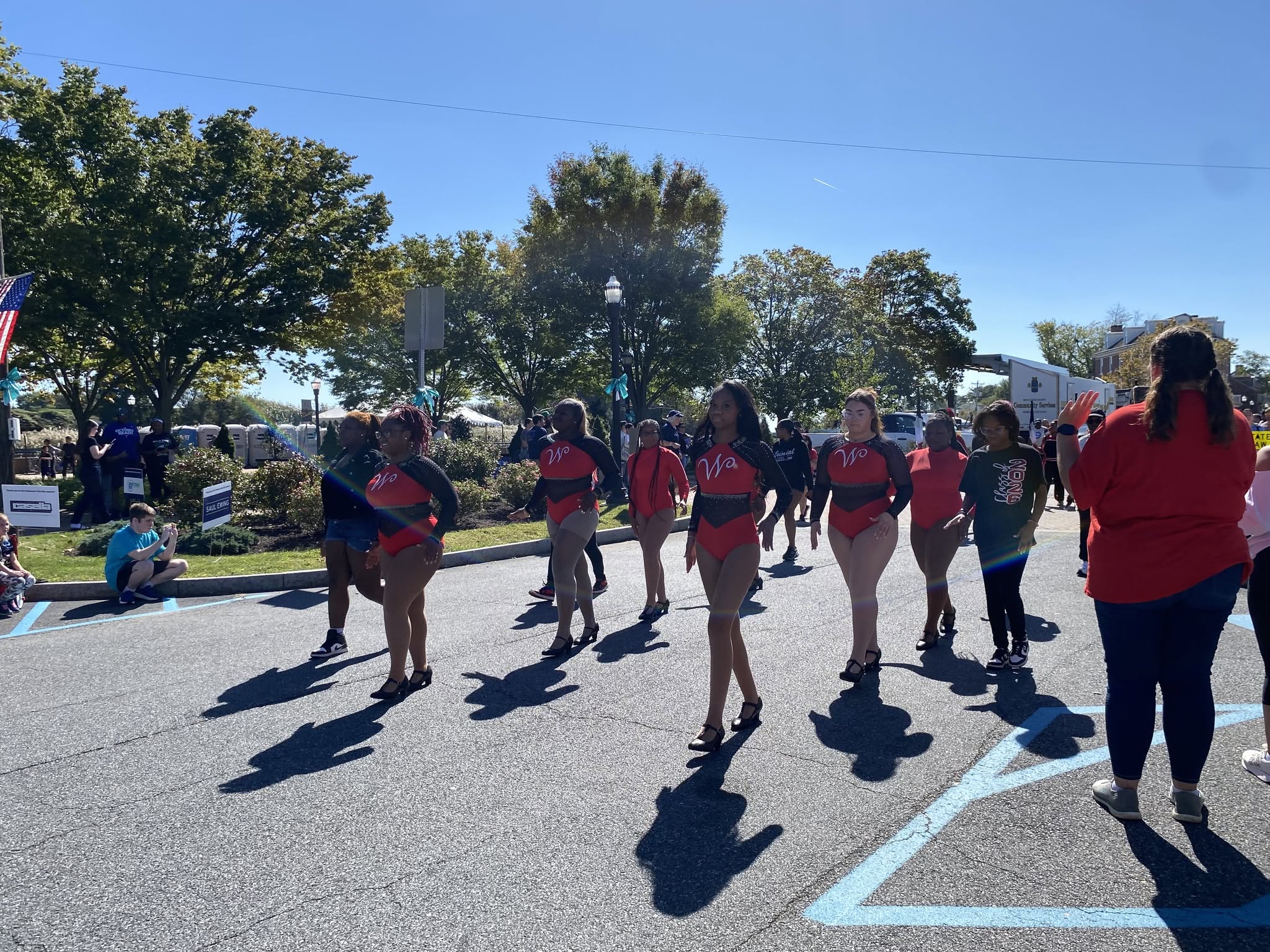 A youth dance team in red shirts performing during the parade