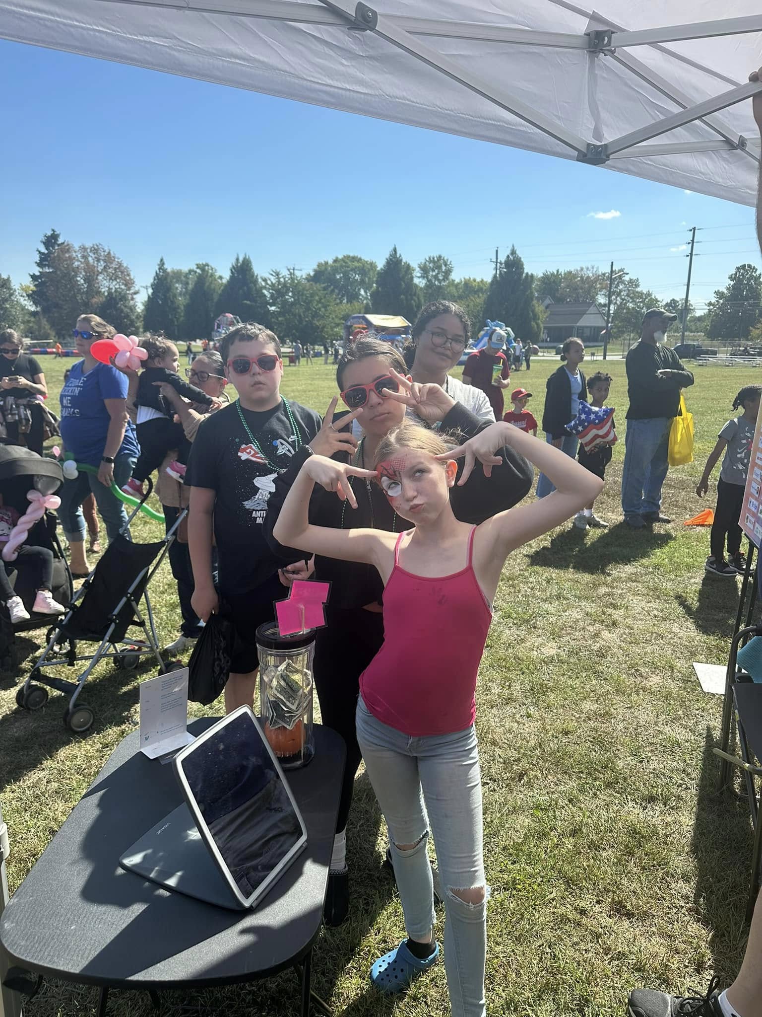 A young girl with arms raised inside an event tent