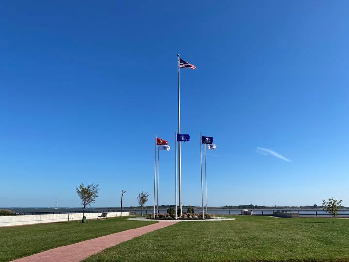 Flagpoles and grass lawn at Battery Park overlooking the water