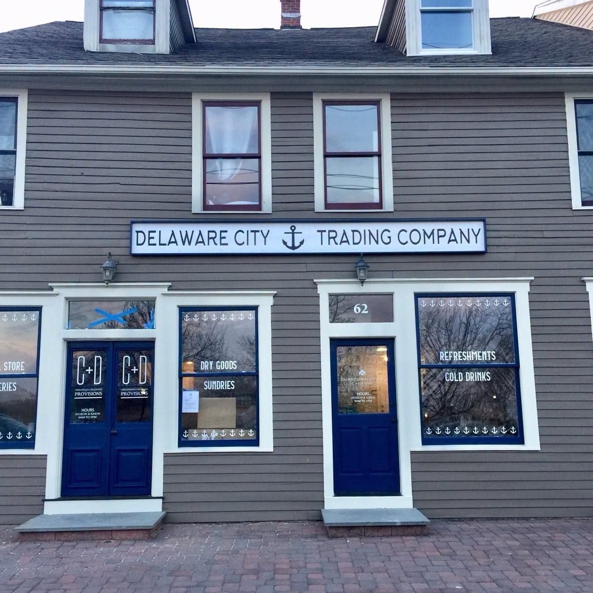 Brick storefront of the Delaware City Trading Company with a black awning
