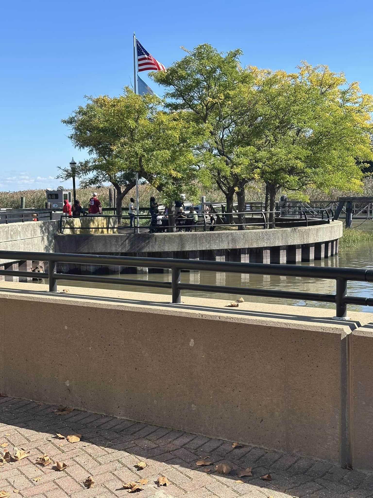 A flag flying above the waterfront promenade in Delaware City